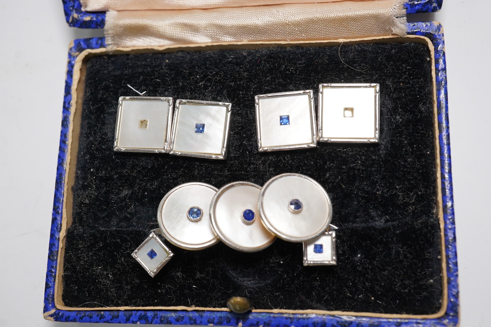 A cased four piece 9ct, mother of pearl and sapphire set dress stud set and three similar 18ct dress studs. Condition - poor to fair